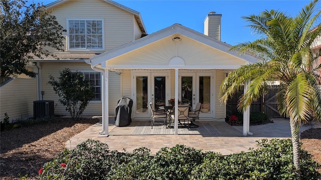 rear view of property with french doors and central AC unit