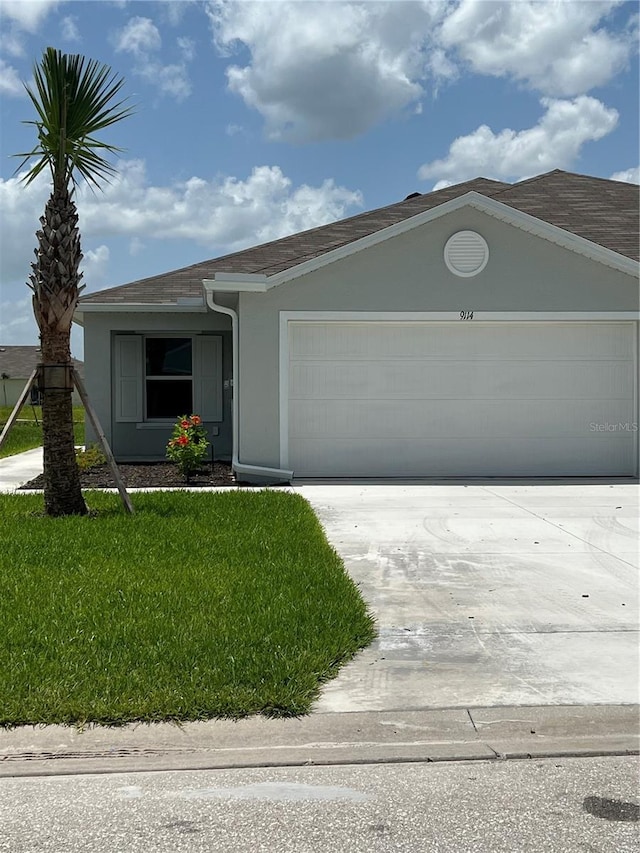 single story home with a front yard and a garage