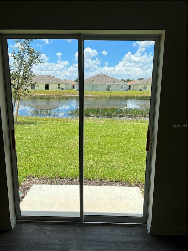 doorway to outside featuring a water view and dark hardwood / wood-style floors