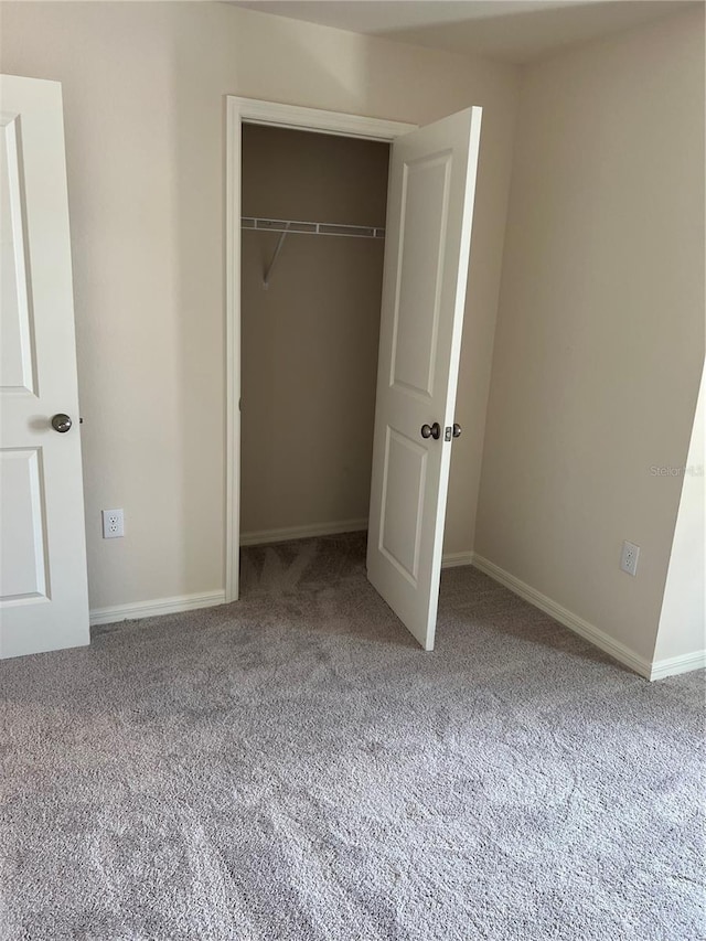 unfurnished bedroom featuring carpet floors and a closet