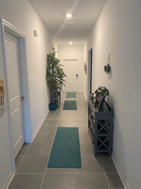 hall featuring dark tile patterned floors