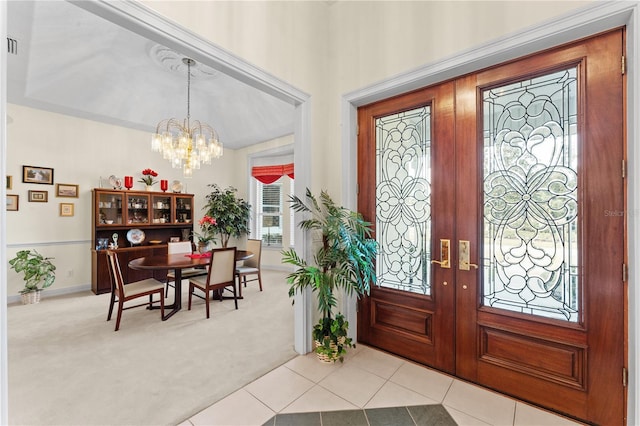 carpeted entryway featuring french doors and a notable chandelier