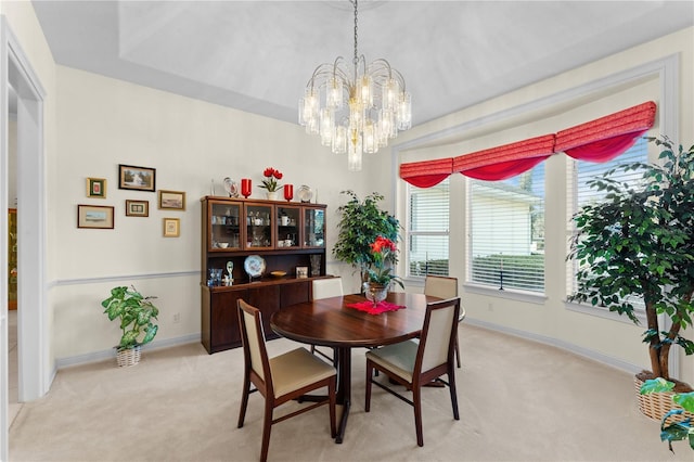 dining area featuring light colored carpet and an inviting chandelier