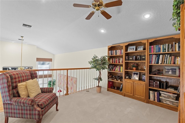 sitting room featuring a textured ceiling, ceiling fan, light carpet, and lofted ceiling