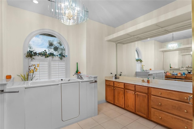 laundry area featuring a notable chandelier, light tile patterned flooring, and separate washer and dryer