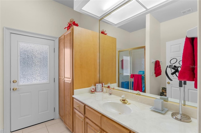 bathroom with tile patterned flooring, vanity, and a shower with shower door