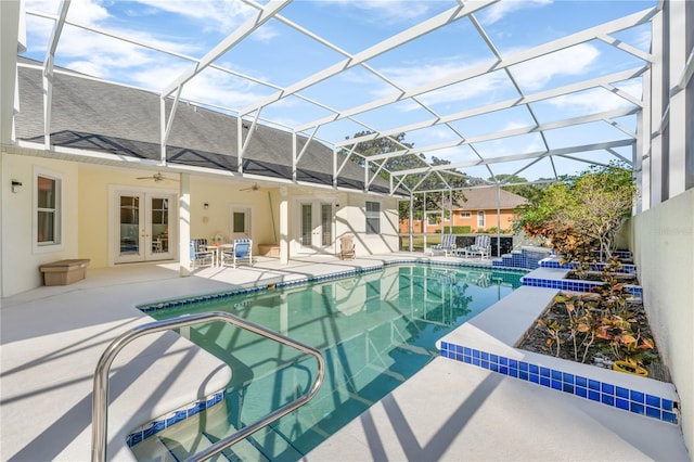 view of swimming pool featuring glass enclosure, a patio area, french doors, and ceiling fan