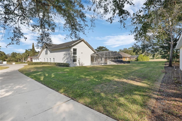 view of home's exterior with a lawn and a lanai