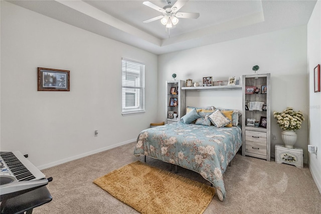 bedroom featuring carpet floors, a tray ceiling, and ceiling fan