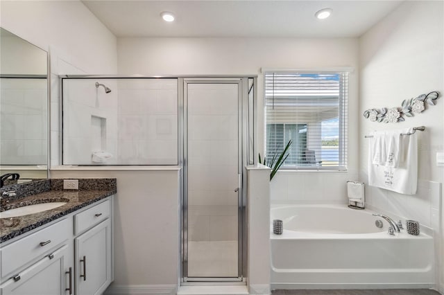 bathroom with vanity and shower with separate bathtub