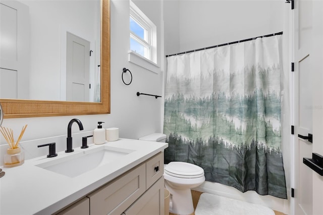 bathroom featuring toilet, vanity, and a shower with curtain