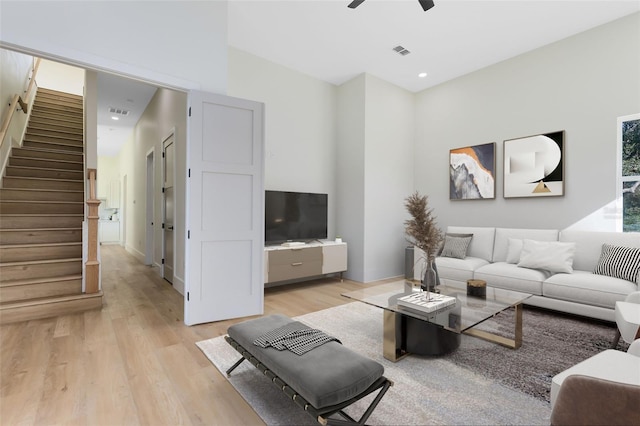 living room featuring light wood-type flooring and ceiling fan