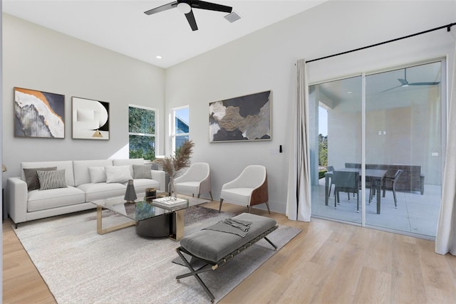 living room featuring ceiling fan and light hardwood / wood-style floors