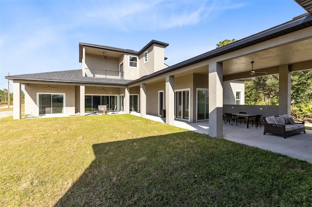 back of property featuring a patio, ceiling fan, and a lawn