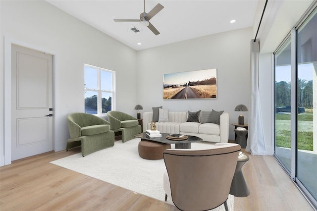 living room with ceiling fan, light hardwood / wood-style floors, and plenty of natural light