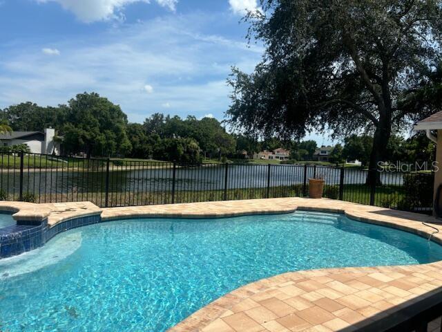 view of swimming pool featuring a water view