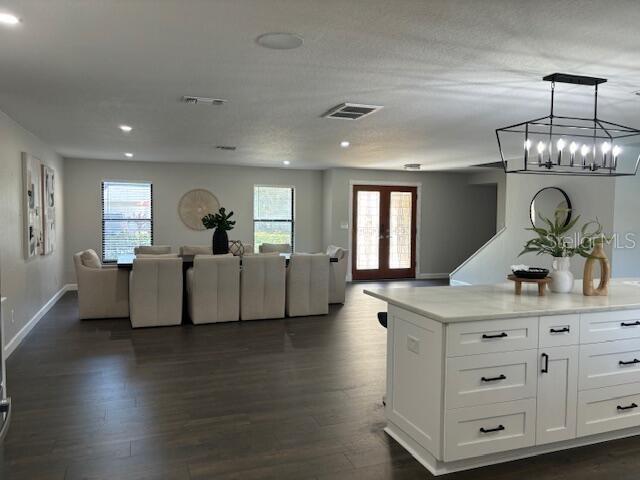 kitchen featuring white cabinets, french doors, dark hardwood / wood-style flooring, and hanging light fixtures