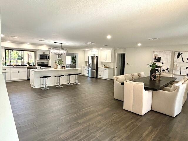 living room with a textured ceiling, sink, and dark wood-type flooring