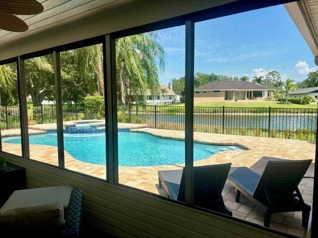 view of swimming pool with an in ground hot tub, a water view, and ceiling fan