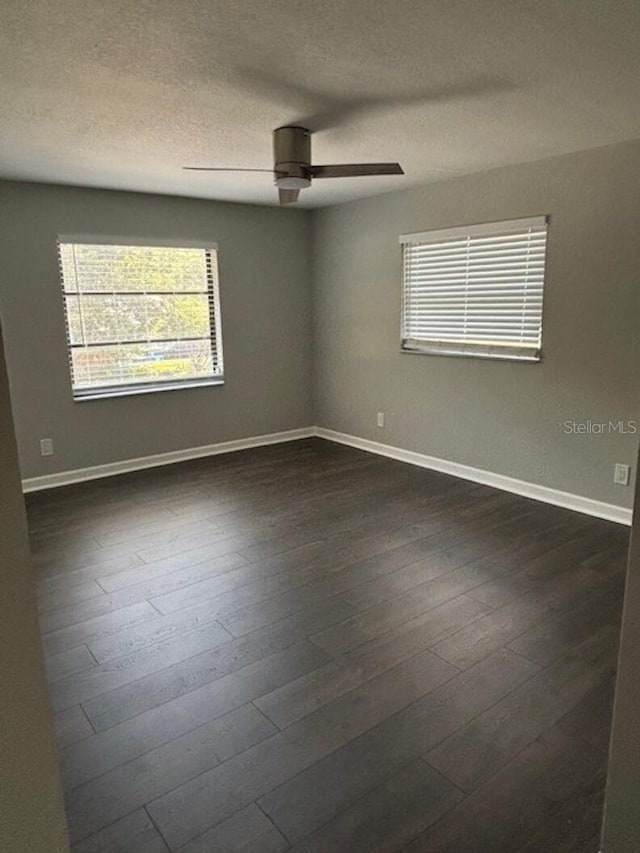 unfurnished room with a textured ceiling, ceiling fan, and dark wood-type flooring