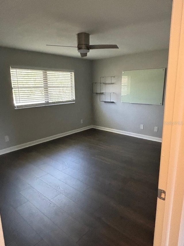 empty room featuring dark hardwood / wood-style flooring and ceiling fan