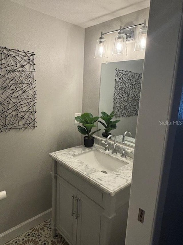 bathroom with tile patterned flooring, a textured ceiling, and vanity