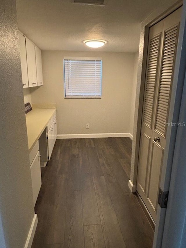 interior space featuring a textured ceiling and dark wood-type flooring