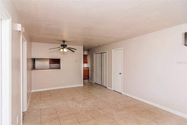 spare room with ceiling fan, a textured ceiling, and light tile patterned floors