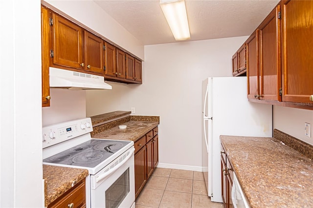 kitchen featuring light tile patterned floors, white appliances, and a textured ceiling