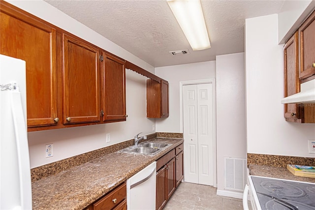 kitchen featuring white appliances, a textured ceiling, sink, and light tile patterned floors