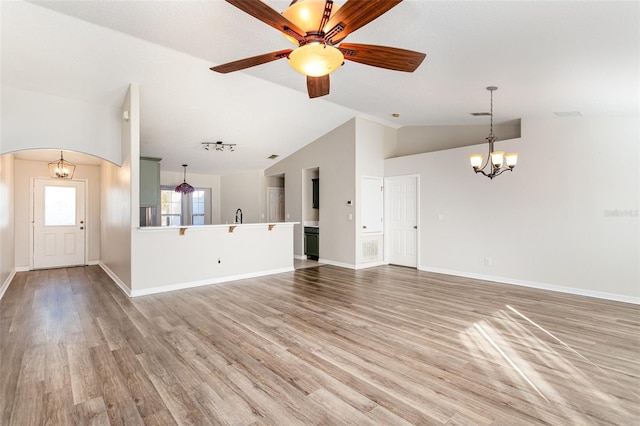 unfurnished living room with ceiling fan with notable chandelier, light hardwood / wood-style floors, and lofted ceiling