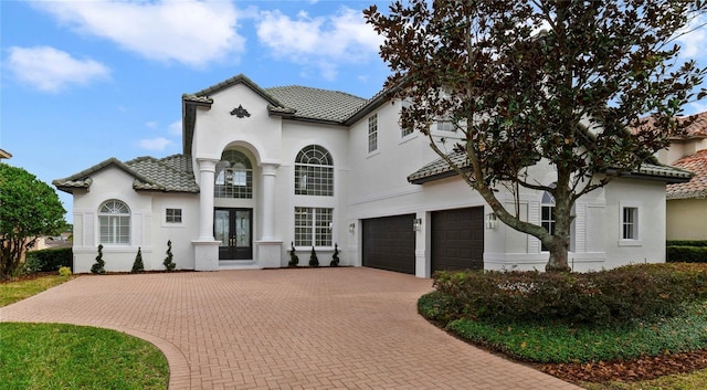 mediterranean / spanish-style house with french doors and a garage