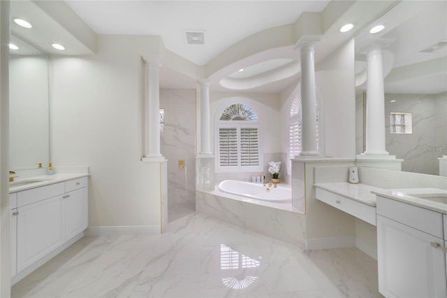 bathroom featuring vanity and tiled tub