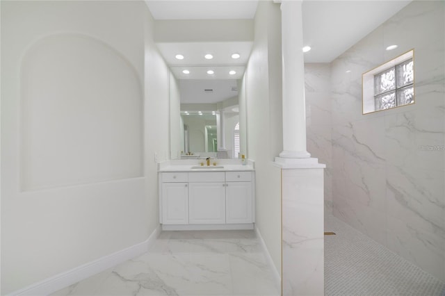 bathroom with vanity, ornate columns, and tiled shower