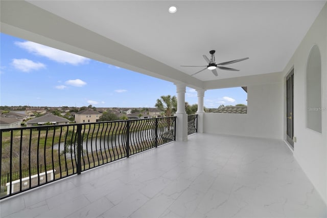 view of patio with ceiling fan and a balcony