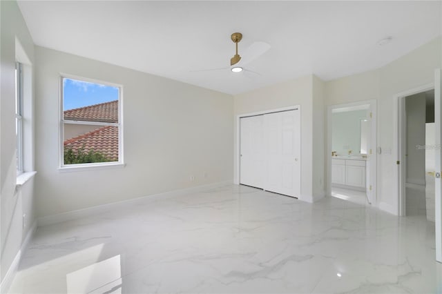 unfurnished bedroom featuring ceiling fan, a closet, and ensuite bathroom