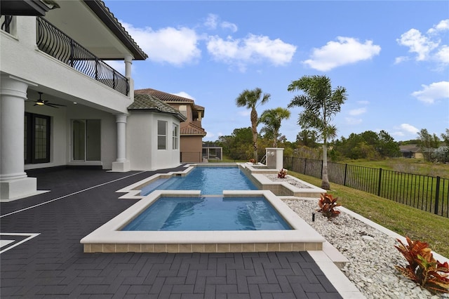 view of pool with ceiling fan, an in ground hot tub, and a patio