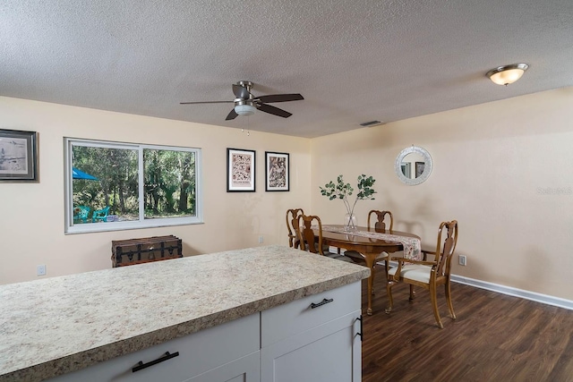 kitchen with ceiling fan, dark hardwood / wood-style flooring, white cabinetry, and a textured ceiling