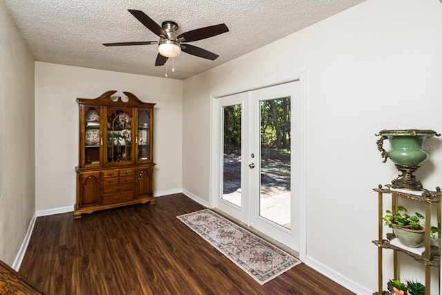 doorway featuring ceiling fan, french doors, dark wood-type flooring, and a textured ceiling