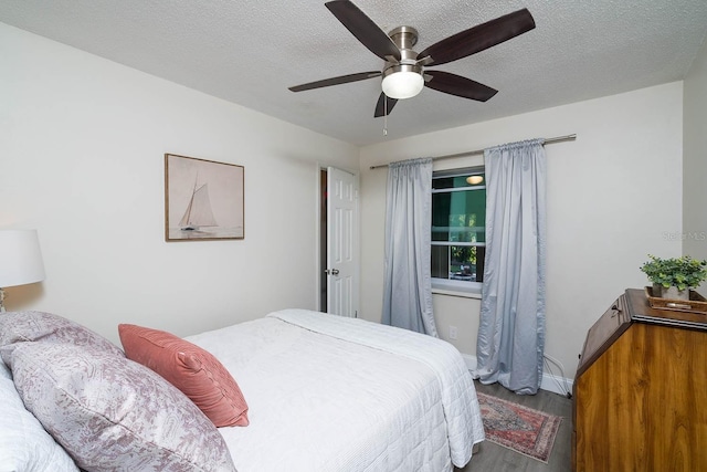 bedroom featuring ceiling fan, hardwood / wood-style floors, and a textured ceiling