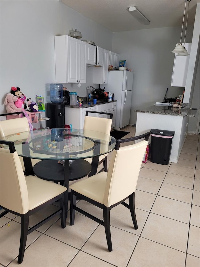 tiled dining room featuring sink