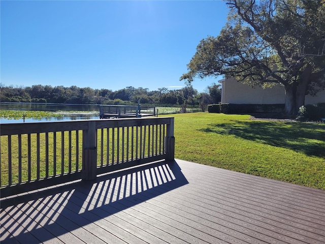 wooden deck featuring a water view and a lawn