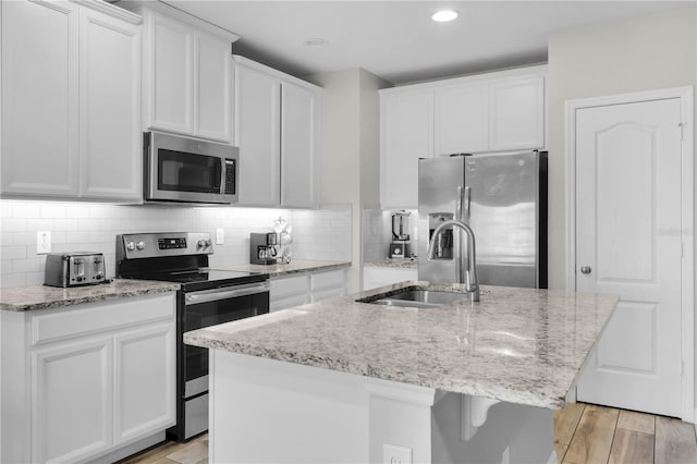 kitchen with sink, white cabinetry, an island with sink, and appliances with stainless steel finishes