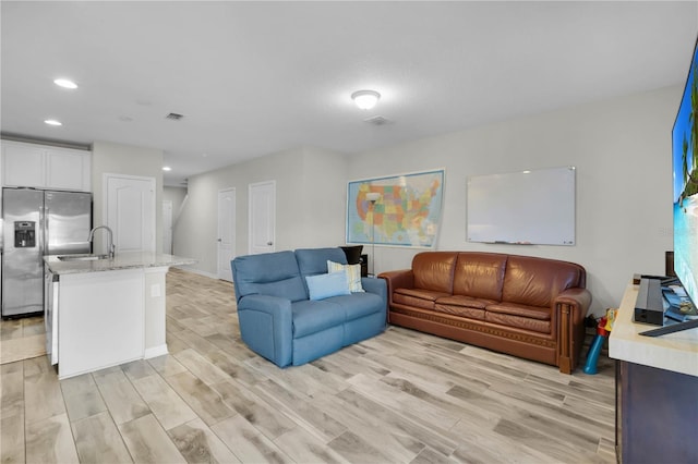 living room featuring light hardwood / wood-style flooring and sink