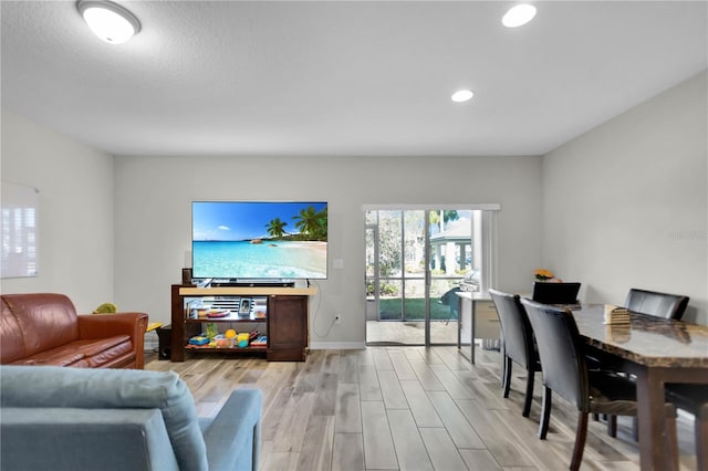 living room with light hardwood / wood-style floors and a textured ceiling