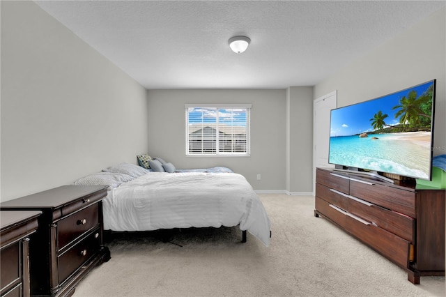 bedroom featuring light colored carpet and a textured ceiling