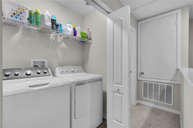 clothes washing area featuring separate washer and dryer and light carpet