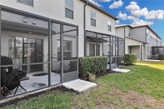 back of property with a yard, central AC unit, and a patio area