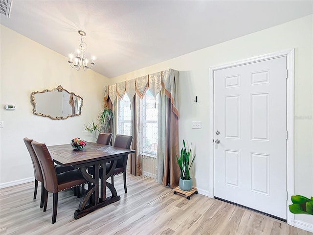 dining room with light hardwood / wood-style floors and an inviting chandelier