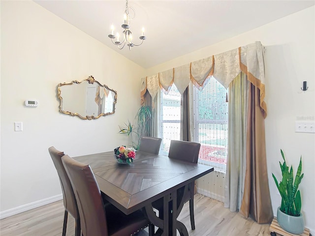 dining room with lofted ceiling, a chandelier, and light hardwood / wood-style floors